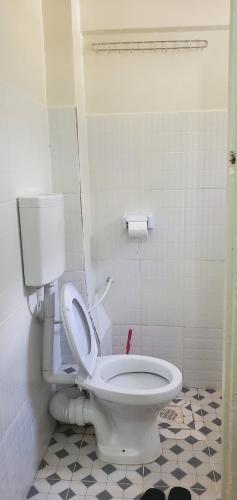 a bathroom with a white toilet in a room at Premier BnB in Meru