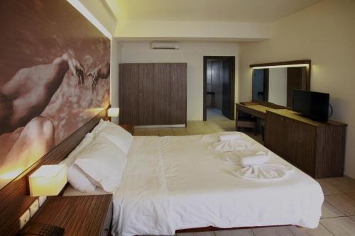 a hotel room with a bed and a desk at Eurohotel Katrin Suites in Stalida