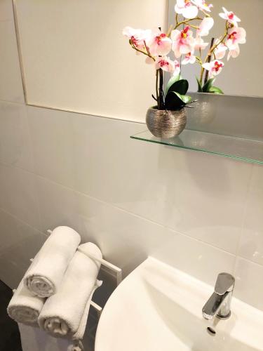 a bathroom with a sink and a mirror and towels at Aparthotel Dat Witte Hus Apartment for 6 guests with 3 rooms in Geesthacht