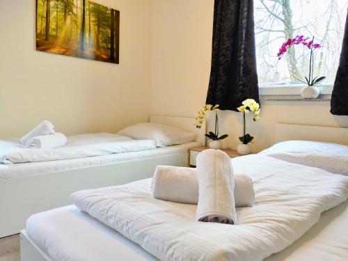 ゲーストハッハトにあるAparthotel Dat Witte Hus Apartment for 6 guests with 3 roomsのベッド2台(タオル付)が備わる客室です。