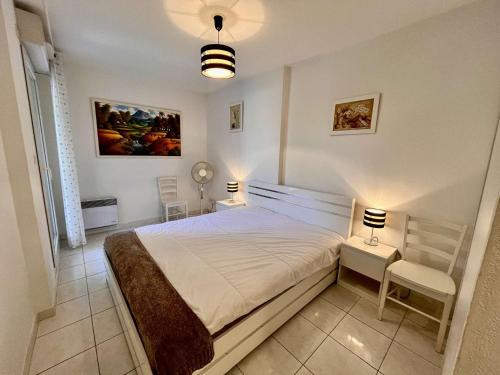 une chambre avec un lit et une chaise dedans dans l'établissement Appartement 2P avec Balcon Proche Centre et Plages - Parking Inclus, Cavalaire - FR-1-226B-127, à Cavalaire-sur-Mer