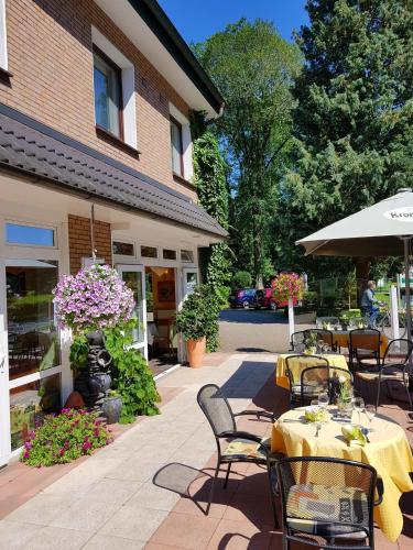a patio with tables and chairs and a building at Gasthof Bucksande in Apen