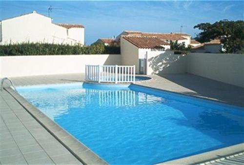 une grande piscine bleue devant une maison dans l'établissement Maison 2 pièces 6 couchages Saint Denis d'Oléron SDO000-080, à Saint-Denis-dʼOléron