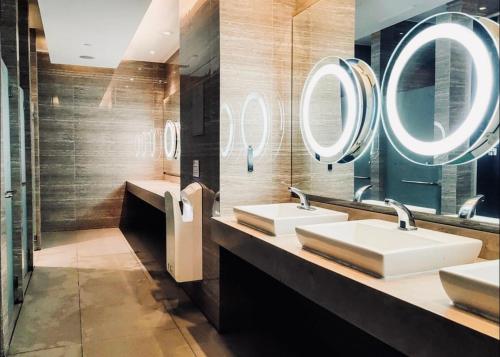 a bathroom with two sinks and two mirrors at Gramercy Residences NEW! Tranquil 1BR Suite, 600mbps WIFI, Netflix & FREE Amenities in Manila