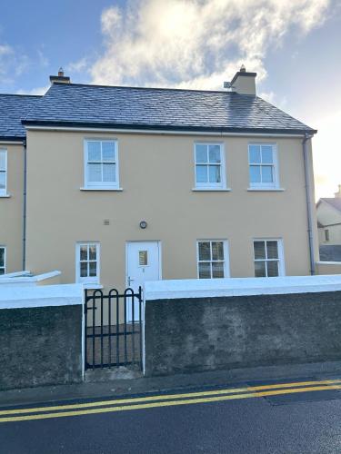 a white house with a fence in front of it at Number 1 Bank House in Schull