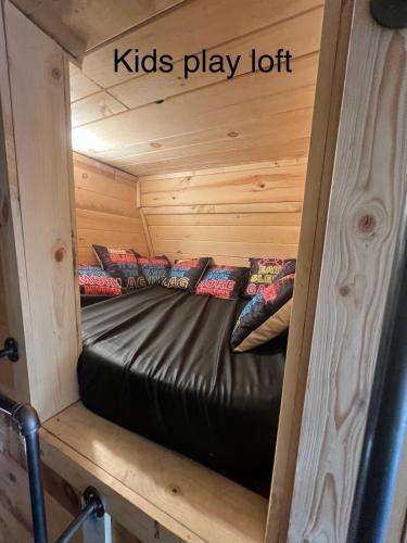 a bed in a log cabin with a kids play lot at Cabin in the treetops! in Lancaster