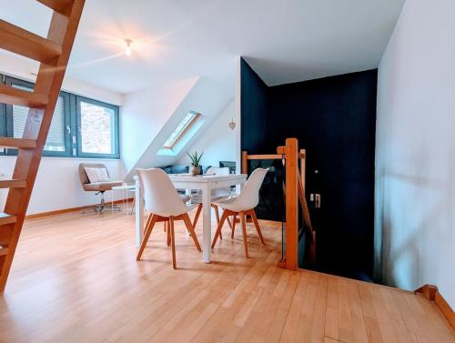 une salle à manger avec une table et des chaises blanches dans l'établissement CityCosy Strasbourg - Le nid de la Cathedrale, à Strasbourg