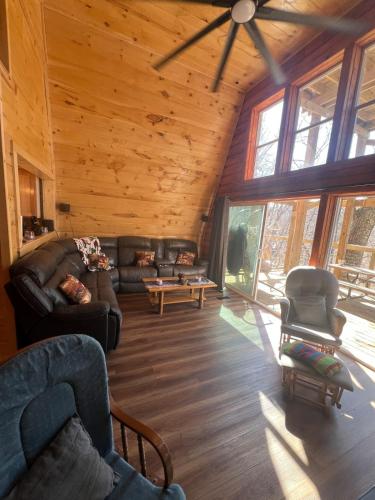 a living room with a couch and chairs in a cabin at Cabin in the treetops! in Lancaster