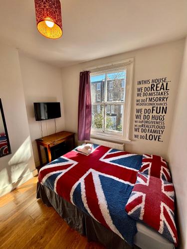 a bedroom with a bed with a red white and blue blanket at Saint James Backpackers in London