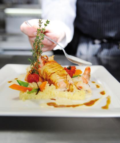 a plate of food with fish on top of rice at Wellings Parkhotel in Kamp-Lintfort