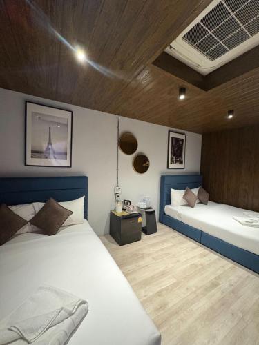 a bedroom with two beds and a ceiling at Icon Hotel Hatyai in Hat Yai
