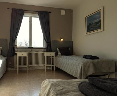 a hotel room with two beds and a window at Brunsbo G:a Biskopsgård Hotell & Konferens in Skara