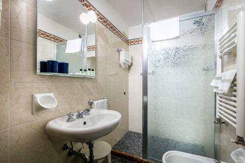 a bathroom with a sink and a glass shower at Hotel Collodi Firenze in Florence