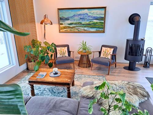 a living room with a couch and a wood stove at Austurey - Lakefront Villa in Laugarvatn