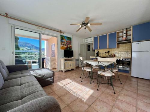 un salon avec un canapé et une table et une cuisine dans l'établissement Appartement T3 avec Terrasse et Clim à 300m de la Plage - FR-1-226B-234, à Cavalaire-sur-Mer