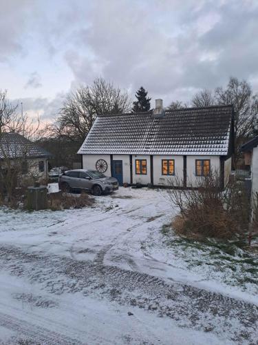a house with a car parked in front of it at Lovely Holiday Home Near Gudhjem in Gudhjem