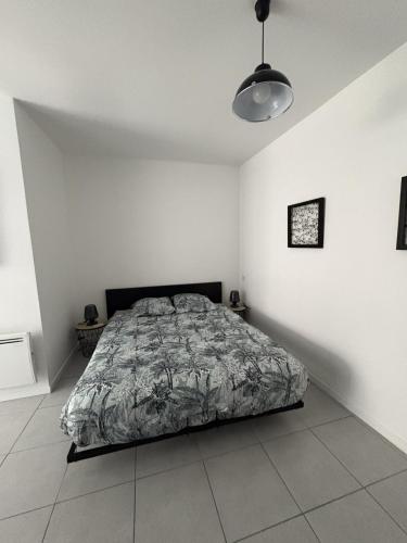 une chambre avec un lit dans une pièce blanche dans l'établissement Appartement moderne centre du Crès, à Le Crès