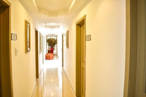 a hallway with white walls and a yellow door at Hotel Cafe Cafe Avenida in Armenia
