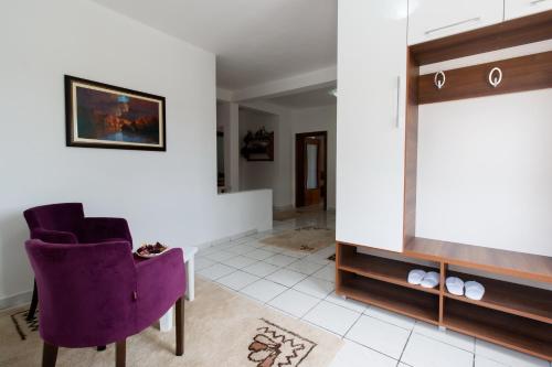 a living room with a purple chair and a tv at Guest House Pasha in Ulcinj