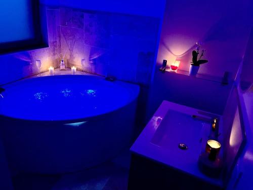 d'une salle de bains pourpre avec baignoire et lavabo. dans l'établissement Maison de vacances à la ferme - Déconnexion en Normandie - Balnéo, à Annouville-Vilmesnil