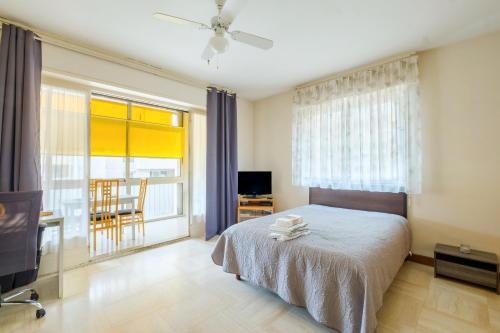a bedroom with a bed and a tv and a window at A quelques pas de la mer in Roquebrune-Cap-Martin