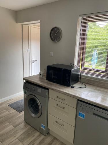 a kitchen with a washing machine and a microwave at Seacoast View in Limavady