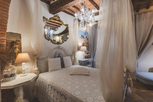 a bedroom with a bed and a chandelier at La Romantica Lolo' in Montepulciano