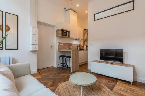 un salon avec un canapé et une table dans l'établissement Grand studio fonctionnel et entièrement rénové, à Tourcoing