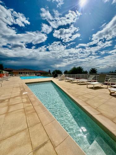 - une piscine avec des chaises longues et des chaises dans un complexe dans l'établissement Le Dolce Vita, à Nice