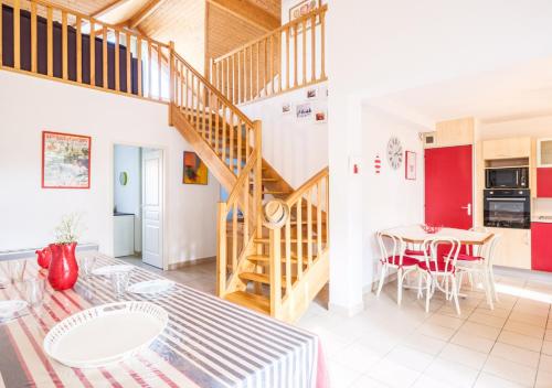 un salon avec un escalier et une table dans l'établissement Confort & Nature près du Lac, à Biscarrosse