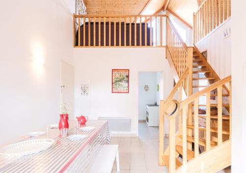 un salon avec une table et un escalier dans l'établissement Confort & Nature près du Lac, à Biscarrosse