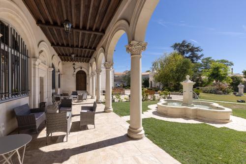 an outdoor patio with a fountain and tables and chairs at Château Pellisson in Cognac