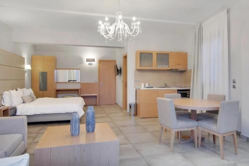 a hotel room with a bed and a dining room at Valtos Beach Hotel in Parga