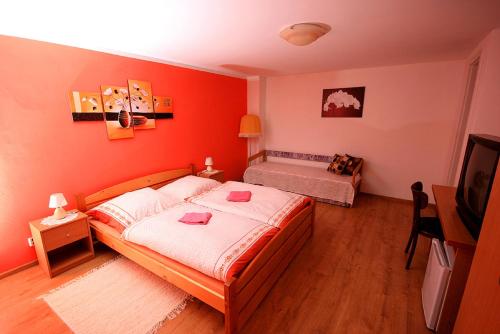 a bedroom with red walls and a bed and a television at Privat Kohut in Štrba