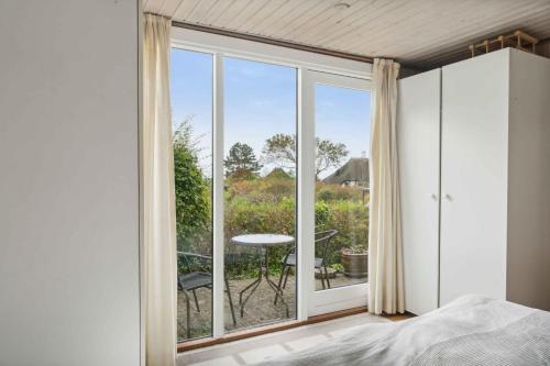 a bedroom with a bed and a large glass window at Holiday Home And Annex Surrounded By Nature in Ebberup