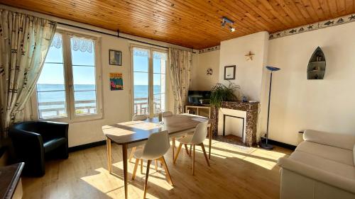 un salon avec une table, des chaises et un canapé dans l'établissement La croisière, Séjournez au cœur de la Baie de Somme dans un logement au charme d’antan !, au Crotoy