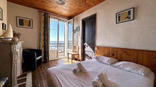 une chambre avec un lit avec vue sur l'océan dans l'établissement La croisière, Séjournez au cœur de la Baie de Somme dans un logement au charme d’antan !, au Crotoy