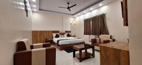 a bedroom with a bed and a living room at New Sun International & Banquet Hall in Jamshedpur