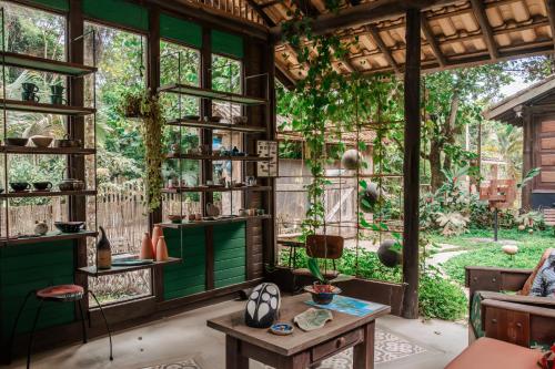 a room with green walls and windows and a table at Atelier Arte Paraty Mirim in Paraty