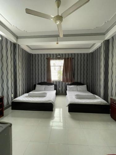 a bedroom with two beds and a ceiling fan at Motel Thiên Phúc 1 in Can Tho