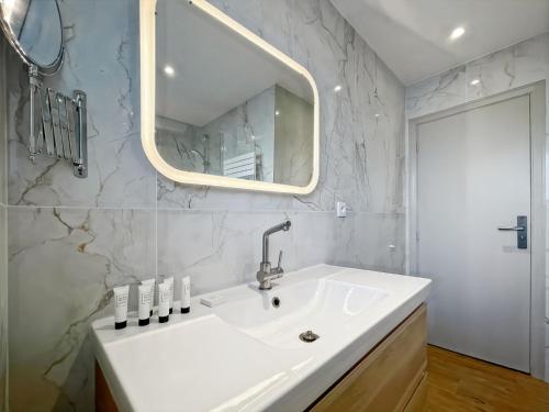 une salle de bain blanche avec un lavabo et un miroir dans l'établissement Deluxe 2 bedroom apartment with parking, à Cannes