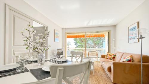 un salon avec une table et un canapé dans l'établissement Deluxe 2 bedroom apartment with parking, à Cannes