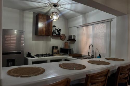 a kitchen with a table and a stove top oven at Ixic posada boutique in Zihuatanejo
