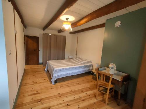 une chambre avec un lit et un parquet dans l'établissement Gite à la campagne, Les Althéas, 3 étoiles, à Malrevers