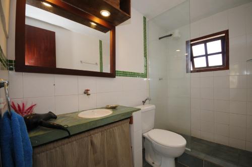 a bathroom with a toilet and a sink and a mirror at Búzios Casa 3 in Búzios