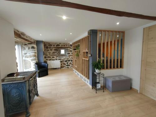 un salon avec une télévision et un mur en pierre dans l'établissement Gite à la campagne, Les Althéas, 3 étoiles, à Malrevers