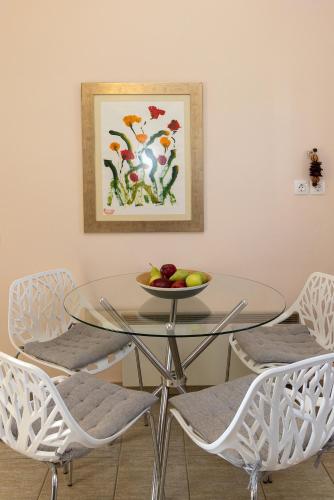 a glass table with chairs and a bowl of fruit on it at So close to the sea in Agios Ioannis Tinos