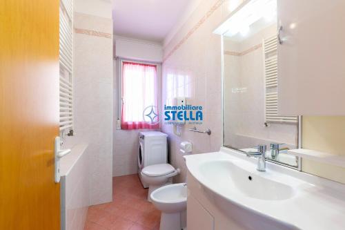 a bathroom with a toilet and a sink and a mirror at Residence Adriatica in Lido di Jesolo
