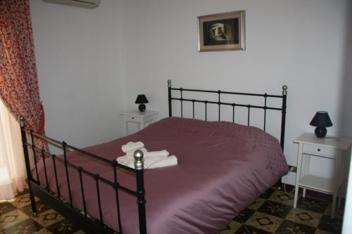 a bedroom with a bed with purple sheets and towels at Casa Barranco in Cefalù
