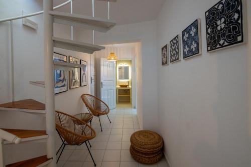 a hallway with chairs and a staircase in a house at So close to the sea in Agios Ioannis Tinos